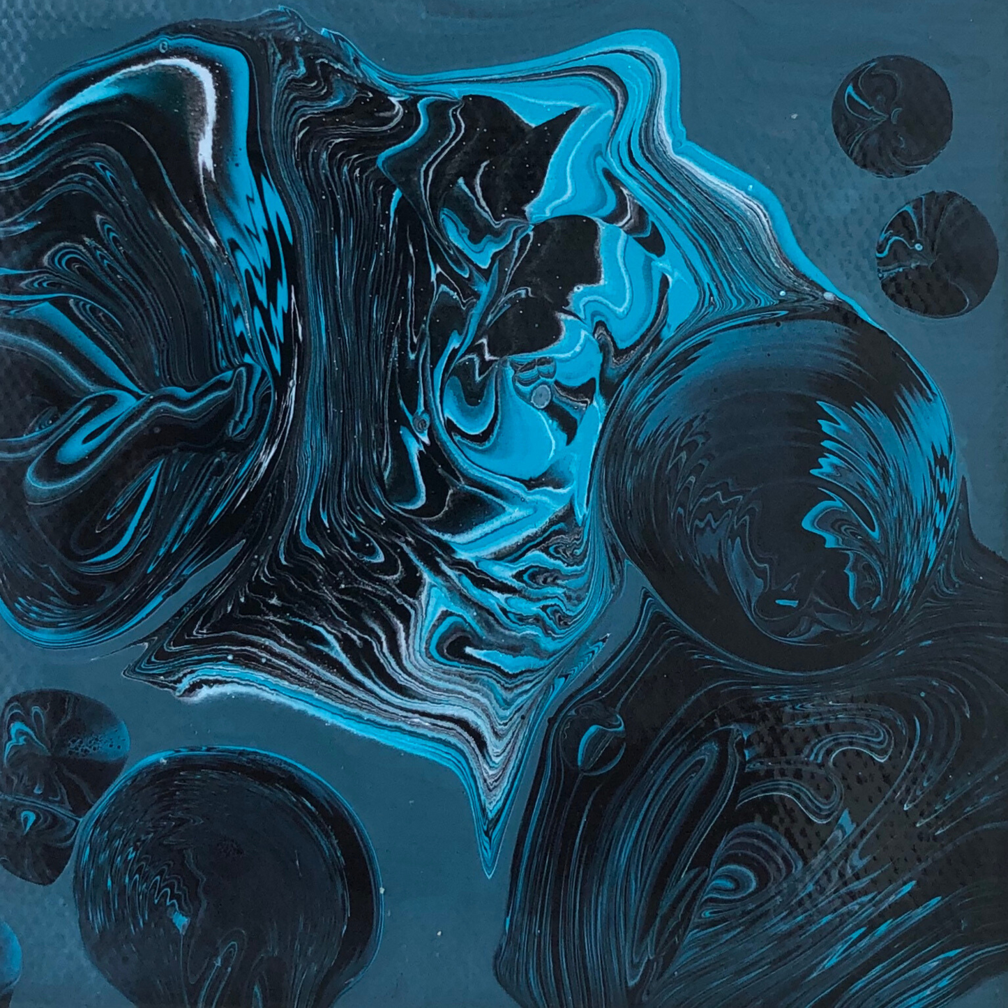 Abstract painting with fluid blue and black forms flowing across a dark teal background, featuring marbled textures and soft circular shapes that appear suspended, creating a sense of depth and weightlessness.